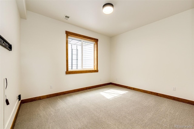 carpeted spare room featuring baseboards