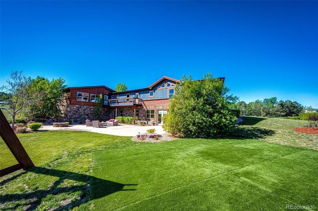 view of grassy yard with a patio area, an outdoor living space, and a wooden deck