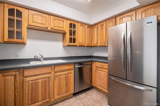 1020 15th St Unit 15G, Denver, CO 80202 - kitchen featuring appliances with stainless steel finishes, dark countertops, glass insert cabinets, light tile patterned floors, and brown cabinetry
