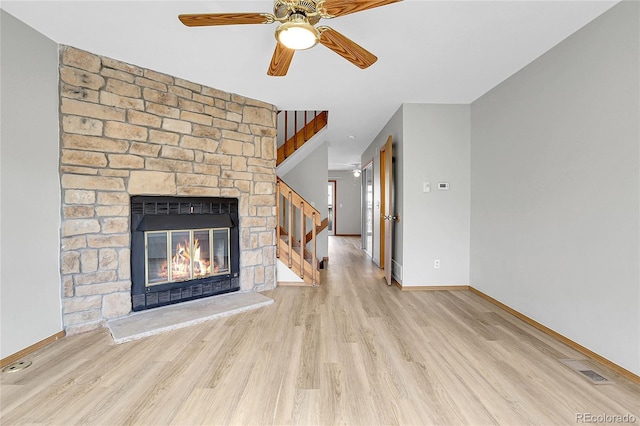 unfurnished living room featuring a fireplace, light wood-type flooring, and ceiling fan