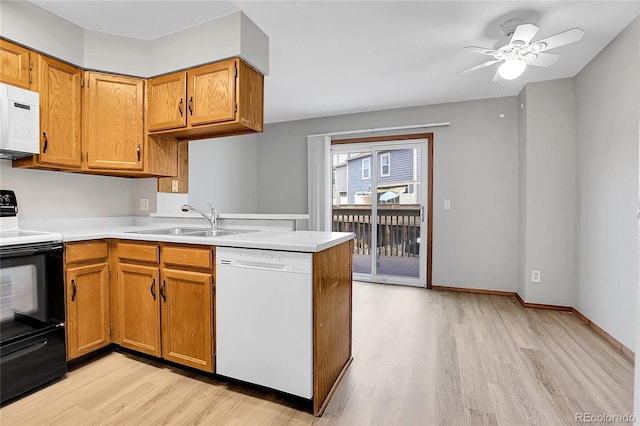 kitchen featuring ceiling fan, sink, light hardwood / wood-style flooring, kitchen peninsula, and white appliances