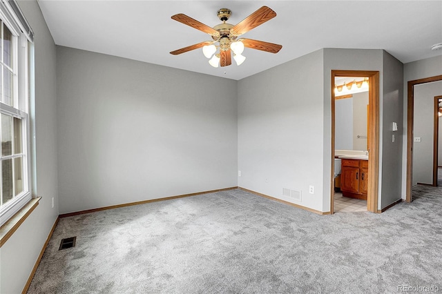 spare room featuring light carpet and ceiling fan