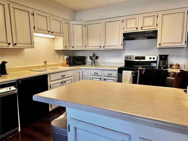 12565 Sheridan Blvd Unit 212, Broomfield, CO 80020 - kitchen featuring black appliances, under cabinet range hood, light countertops, dark wood-style flooring, and a breakfast bar