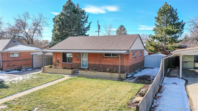 view of front facade featuring brick siding, a shingled roof, a front yard, and fence