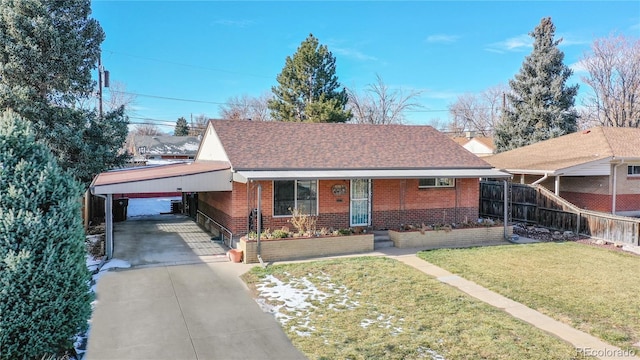 view of front of home with a front lawn, a carport, brick siding, and driveway