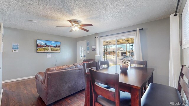 dining room with wood finished floors, a ceiling fan, baseboards, and a textured ceiling