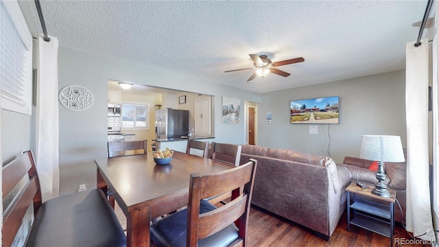 dining area with a textured ceiling, dark wood finished floors, and a ceiling fan