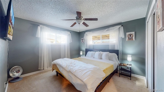 bedroom with a textured ceiling, baseboards, carpet floors, and ceiling fan
