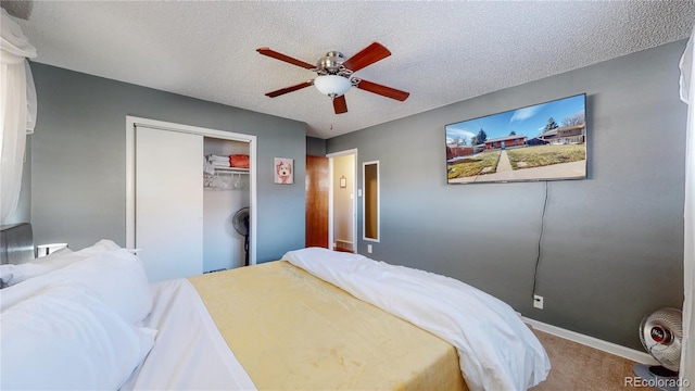bedroom with baseboards, carpet floors, a closet, a textured ceiling, and a ceiling fan