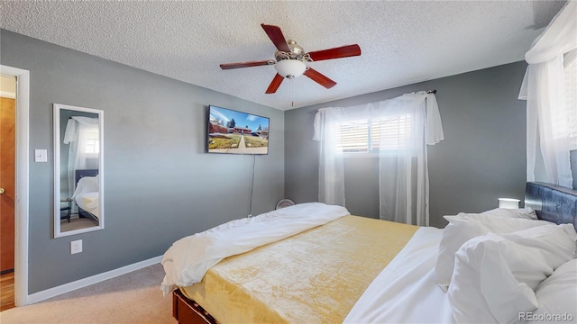 carpeted bedroom with baseboards, a textured ceiling, and a ceiling fan