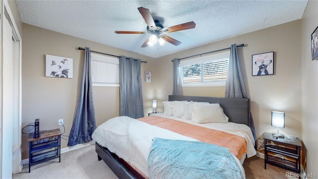 carpeted bedroom with a ceiling fan and a textured ceiling