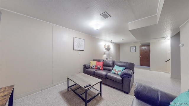 living area with visible vents, a textured ceiling, and carpet