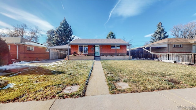 view of front of home featuring brick siding, fence, a front yard, a carport, and driveway