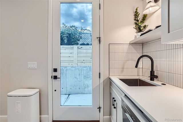 4025 Jason St Unit 101, Denver, CO 80211 - kitchen featuring tasteful backsplash, light countertops, dishwashing machine, and white cabinets