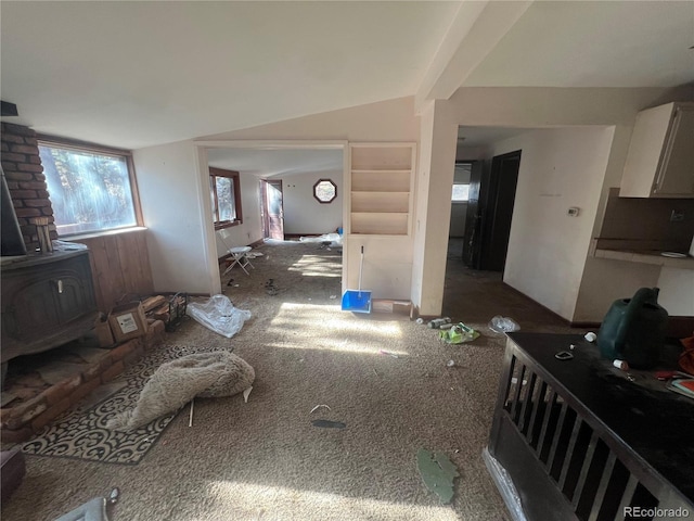 living room with lofted ceiling and a wood stove