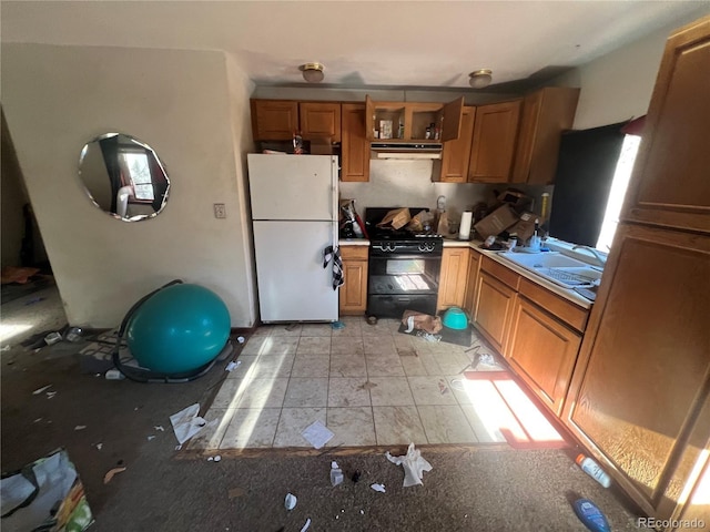 kitchen featuring black gas range and white fridge