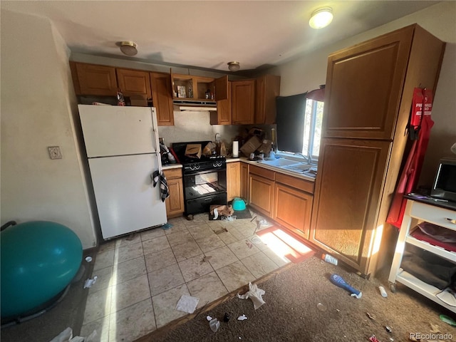 kitchen featuring white fridge, light tile patterned floors, and black gas range