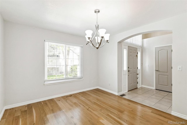 7400 W Grant Ranch Blvd Unit 52, Littleton, CO 80123 - empty room with arched walkways, a chandelier, and light wood finished floors