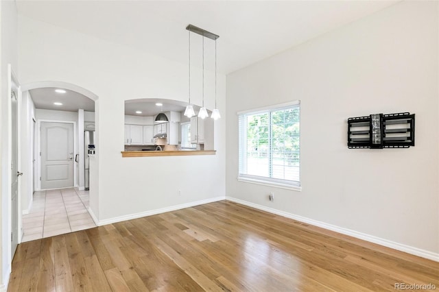 7400 W Grant Ranch Blvd Unit 52, Littleton, CO 80123 - unfurnished dining area with light wood-style flooring, arched walkways, and recessed lighting