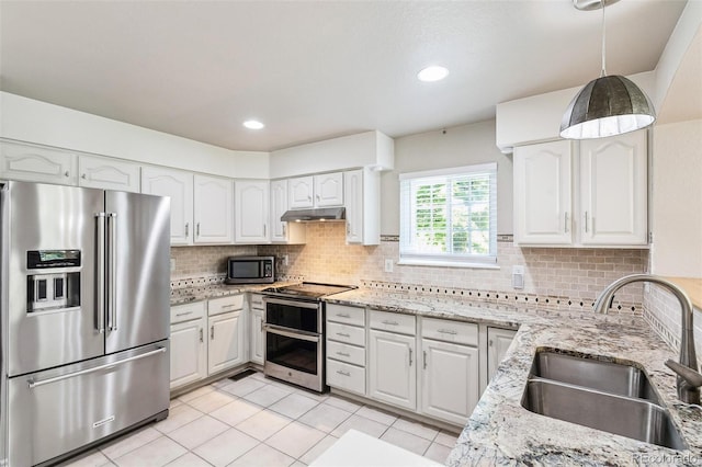 7400 W Grant Ranch Blvd Unit 52, Littleton, CO 80123 - kitchen with stainless steel appliances, light stone countertops, white cabinets, decorative backsplash, and light tile patterned floors