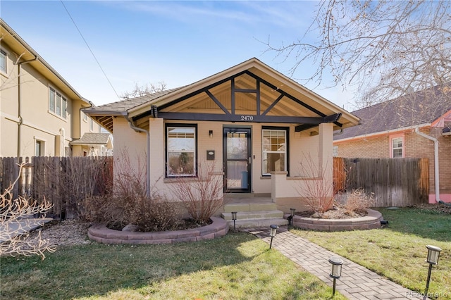 bungalow-style home with covered porch and a front lawn