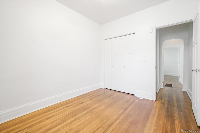 unfurnished bedroom with hardwood / wood-style flooring and a closet