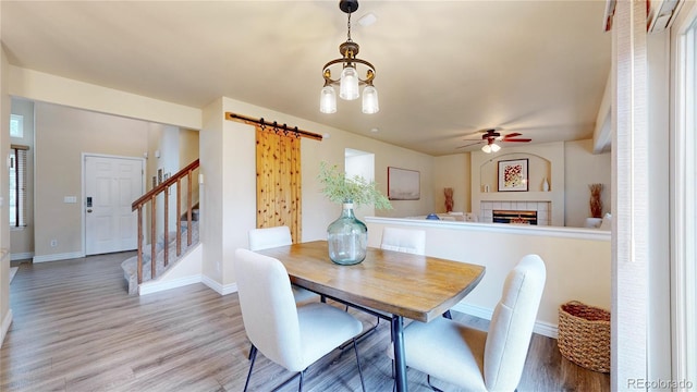 11301 Vernon Way, Parker, CO 80134 - dining area featuring a barn door, a ceiling fan, light wood-style floors, and baseboards
