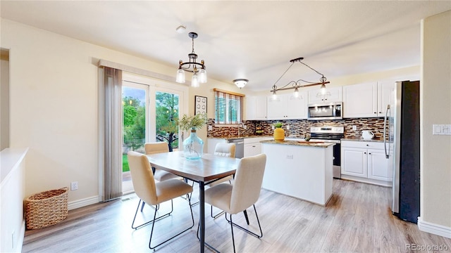 11301 Vernon Way, Parker, CO 80134 - dining space featuring light wood finished floors, a chandelier, and baseboards