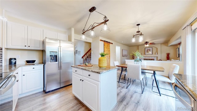 11301 Vernon Way, Parker, CO 80134 - kitchen with appliances with stainless steel finishes, a ceiling fan, light wood-style flooring, hanging light fixtures, and white cabinetry