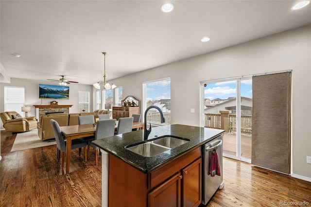 kitchen featuring sink, hardwood / wood-style flooring, dishwasher, an island with sink, and pendant lighting