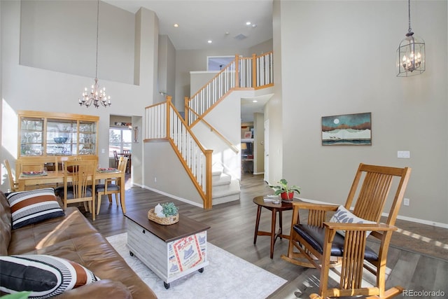 living room with wood-type flooring, an inviting chandelier, and a high ceiling