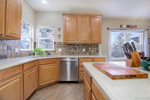 kitchen featuring sink, backsplash, stainless steel dishwasher, and plenty of natural light