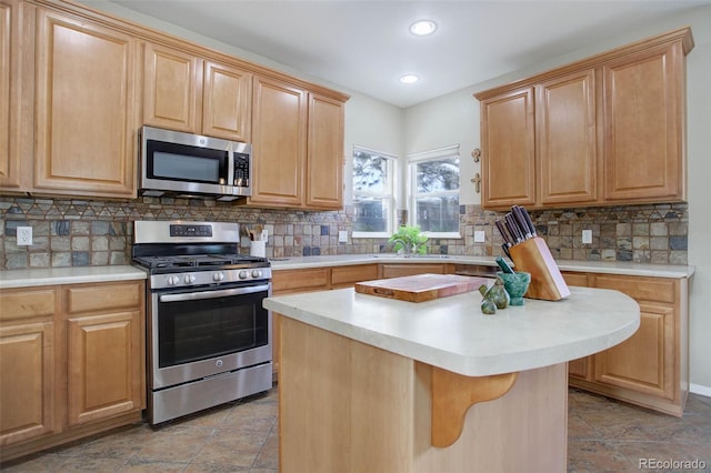 kitchen with stainless steel appliances, a center island, a kitchen bar, and tasteful backsplash