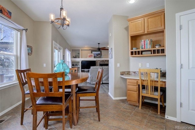 dining room with ceiling fan with notable chandelier and a wealth of natural light