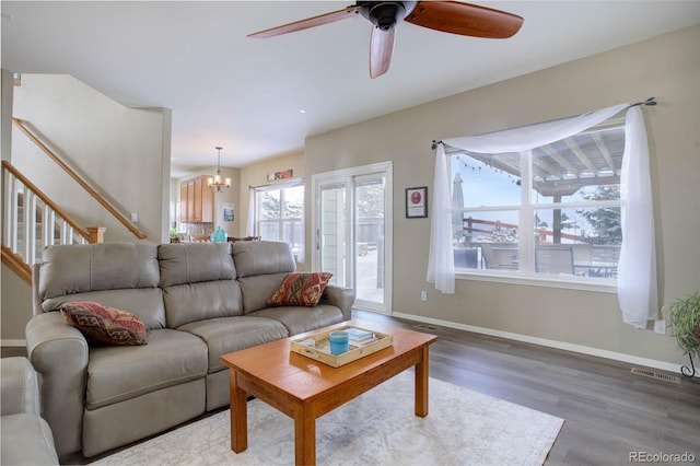 living room featuring ceiling fan with notable chandelier and wood-type flooring