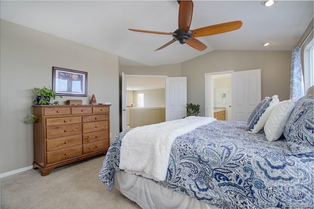 carpeted bedroom featuring ceiling fan, connected bathroom, and lofted ceiling