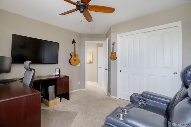 carpeted home office featuring ceiling fan