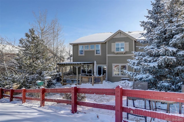 snow covered rear of property featuring covered porch