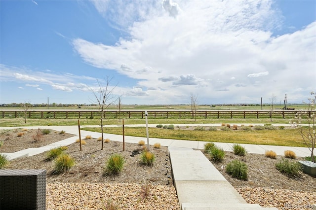 view of yard with a rural view and fence