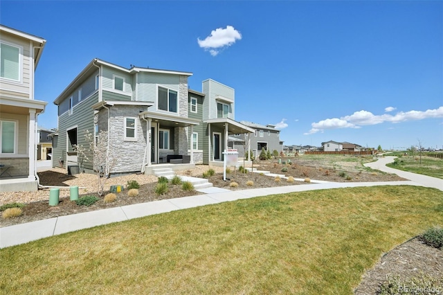 view of front of house featuring a front lawn and stone siding