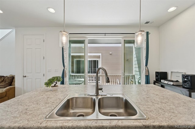 kitchen featuring visible vents, pendant lighting, a sink, light countertops, and recessed lighting