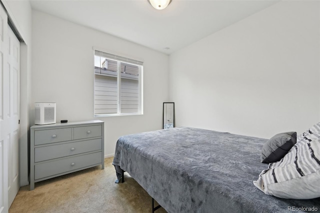 bedroom with light carpet and a closet