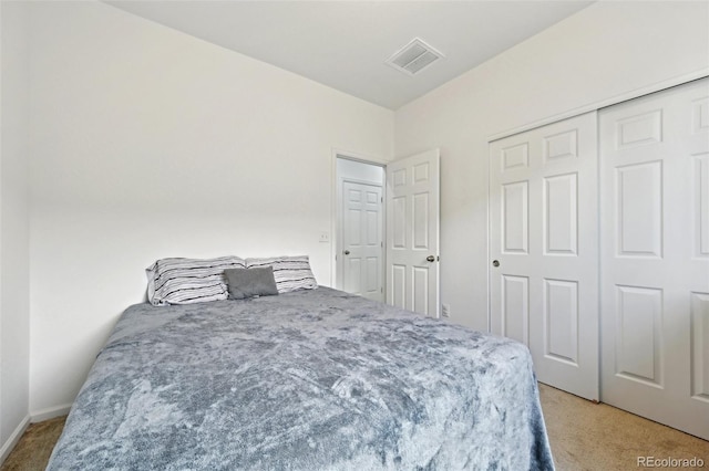 bedroom featuring baseboards, visible vents, light carpet, and a closet