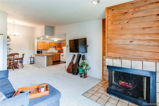 2280 S Oswego Way Unit 303, Aurora, CO 80014 - living area with a tile fireplace, a chandelier, light colored carpet, and a textured ceiling