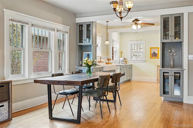 dining area featuring baseboards, a wealth of natural light, ceiling fan, and light wood-type flooring