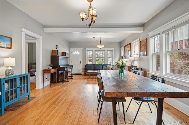 dining room with an inviting chandelier, light wood-style flooring, baseboards, and beamed ceiling