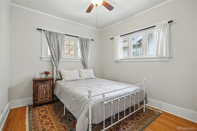 bedroom featuring ornamental molding, baseboards, a ceiling fan, and wood finished floors