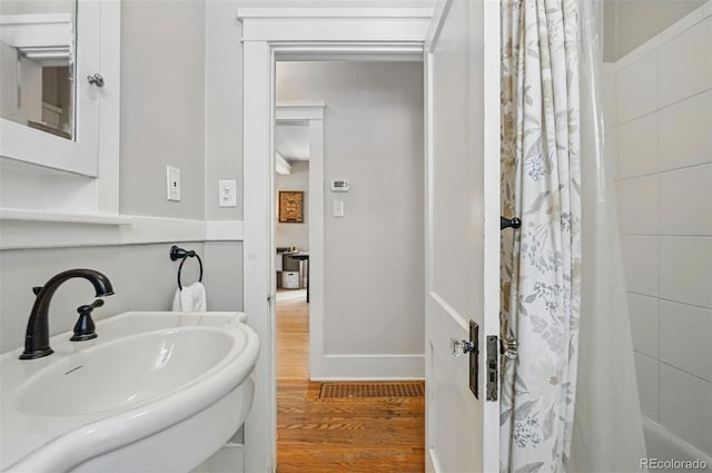 full bath featuring wood finished floors and a sink