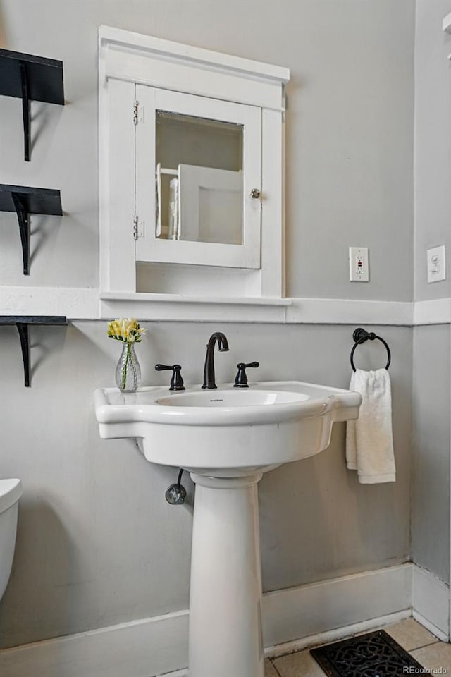 bathroom featuring toilet, tile patterned flooring, and baseboards