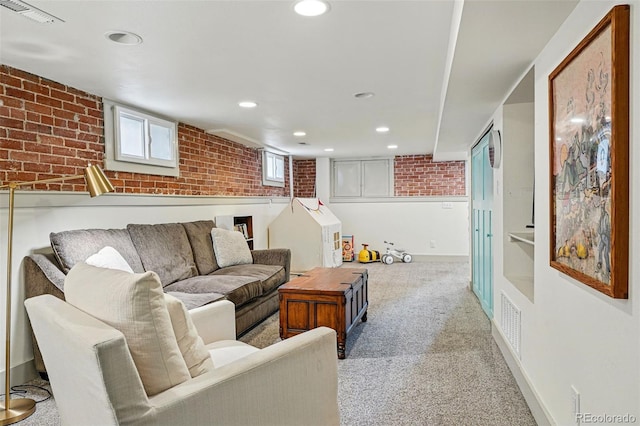carpeted living room with recessed lighting, visible vents, and brick wall